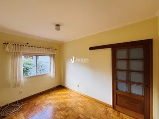 Ambiente interno com piso de madeira e janela.