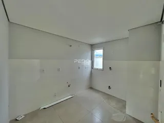 Ambiente interno de uma sala com paredes brancas e piso claro.
