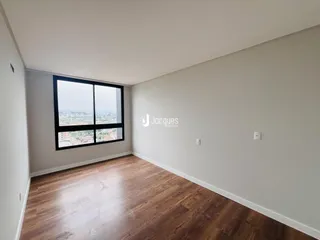 Sala com piso de madeira e vista da cidade.