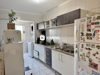 Cozinha com armários brancos e bancada de granito.