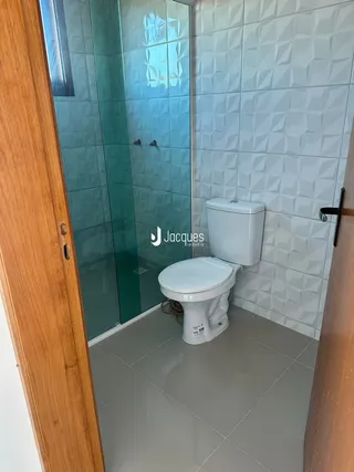 Foto de um banheiro com azulejos brancos e um vaso sanitário.