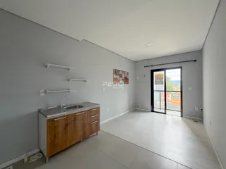 Vista interna de uma cozinha moderna com armários de madeira e piso claro.