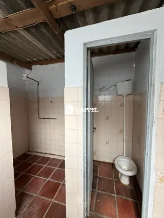 Foto interna de um banheiro com piso de cerâmica e paredes claras.