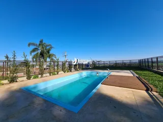 Piscina externa com deck de madeira em uma área ao ar livre.