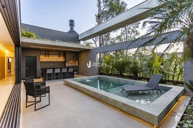 Vista de uma área externa com piscina e deck em uma residência moderna.