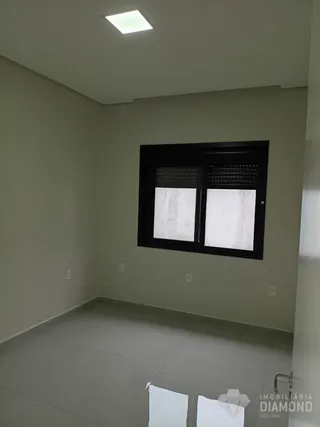 Vista interna de um ambiente com paredes lisas e uma janela escura.