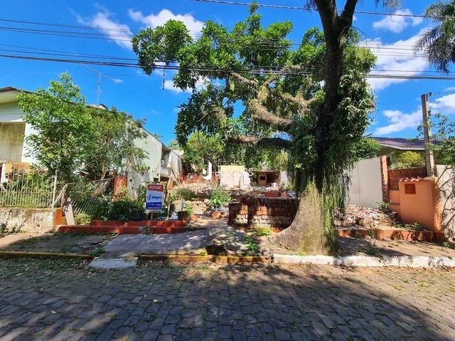 Vista da fachada de uma propriedade em Lajeado, Brasil, com jardim e árvores.