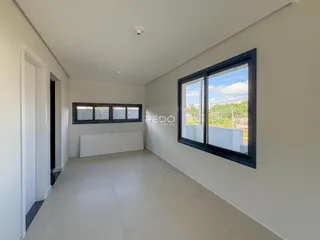 Corredor interno de um imóvel em Lajeado, Brasil, com grandes janelas.