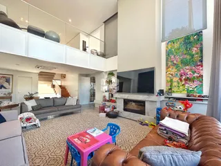 Sala de estar com lareira e televisão em um apartamento no Brasil.