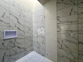 Parede com revestimento de azulejos e detalhes em mármore em um ambiente interno.