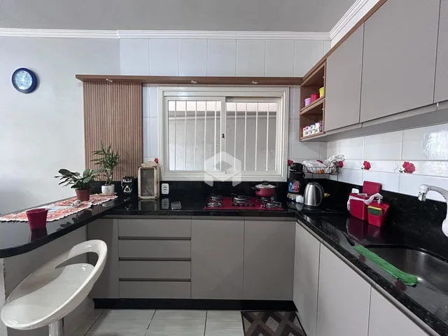 Foto de uma cozinha com armários e bancadas escuras.