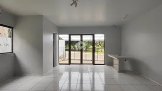 Ambiente interno de uma sala ampla com piso de cerâmica e portas de vidro.