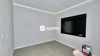 Foto de um cômodo interno com paredes brancas e piso claro.