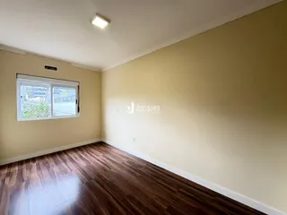 Foto de uma sala com piso de madeira e paredes claras.