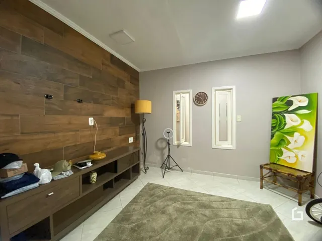 Sala de estar com painel de madeira e piso de cerâmica.