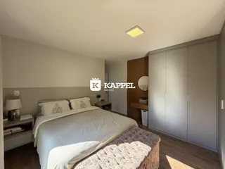 Quarto com cama e armário em um ambiente claro.