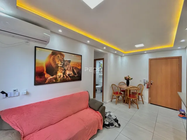 Sala de estar moderna com sofá rosa e televisão na parede.