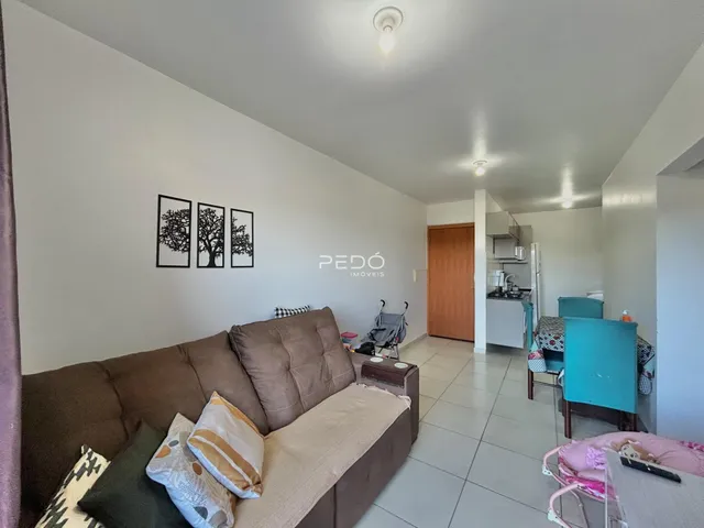 Sala de estar com sofá marrom e paredes brancas.