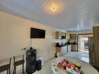 Imagem de uma sala de estar com área de jantar e cozinha em um imóvel.