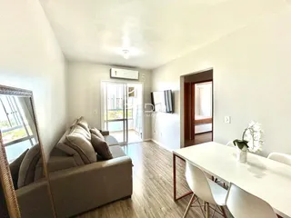 Sala de estar com sofá e mesa de jantar em um imóvel no Brasil.