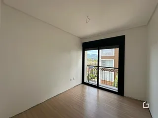 Interior de um ambiente com piso de madeira e vista para o exterior.