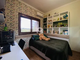 Quarto com parede de adesivo de carros e janela grande em Lajeado.