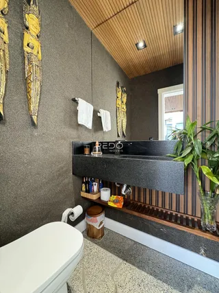 Foto de um banheiro com decoração de parede e bancada escura.