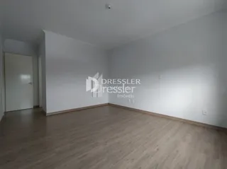 Ambiente interno de uma sala com piso de madeira.