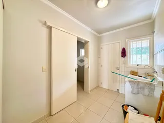 Corredor interno com piso de cerâmica e portas brancas.