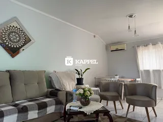 Foto da sala de estar mostrando um sofá e poltronas.