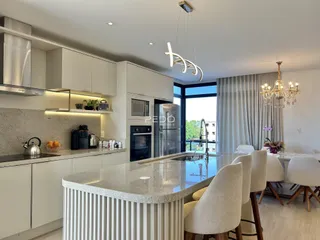 Cozinha moderna com ilha e área de jantar em um apartamento em Lajeado.