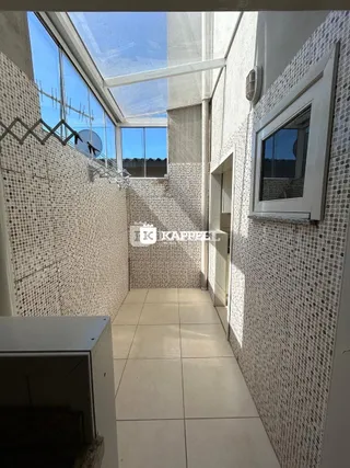 Foto de um corredor interno com paredes de azulejos e piso de cerâmica.