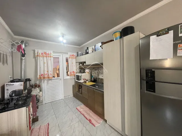 Foto interna de uma cozinha com armários e piso de cerâmica.
