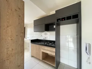 Vista da cozinha moderna com armários escuros e revestimento branco.