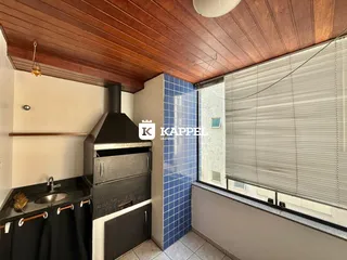 Uma cozinha com bancada escura e revestimento de azulejos azuis e brancos.