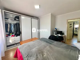 Quarto com cama grande e armário branco.