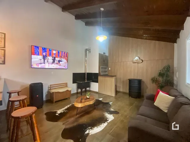 Sala de estar com piso de madeira e teto de madeira aparente.