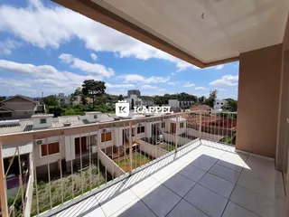 Varanda com vista para outros telhados e vegetação na residência.