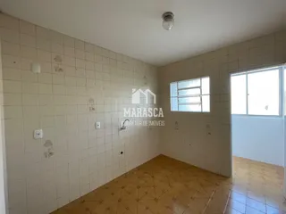 Interior de um corredor com paredes de azulejo e piso de cerâmica.