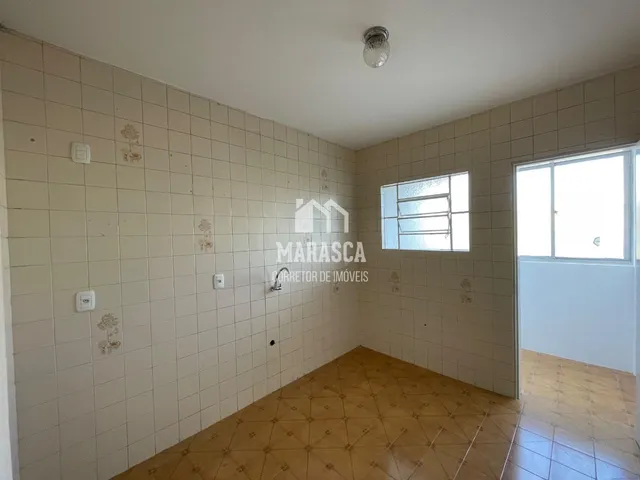 Interior de um corredor com paredes de azulejo e piso de cerâmica.
