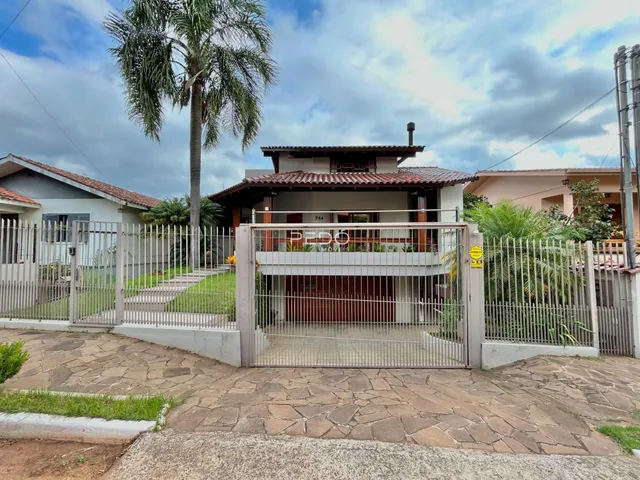 A fachada de uma casa em Lajeado, Brasil, com portão de ferro e cerca.