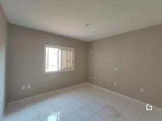 Ambiente interno com piso de cerâmica e janela em uma sala.