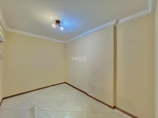 Vista interna de um cômodo com paredes claras e piso de cerâmica.