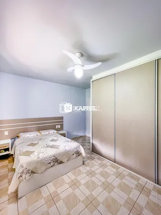Quarto com cama e armários em um ambiente claro.