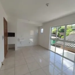 Ambiente interno com piso de cerâmica e portas de vidro que dão acesso ao exterior.