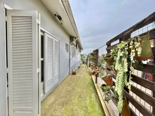 Vista lateral da fachada de uma residência em Lajeado, Brasil, com jardim e cerca de madeira.