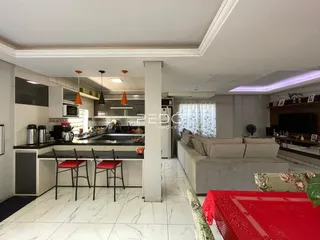 Sala de estar e cozinha integradas com piso de porcelanato claro.