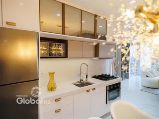 Cozinha moderna com armários brancos e bancada de mármore.