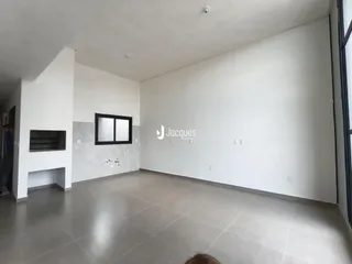 Foto de um ambiente interno com paredes brancas e piso de concreto.