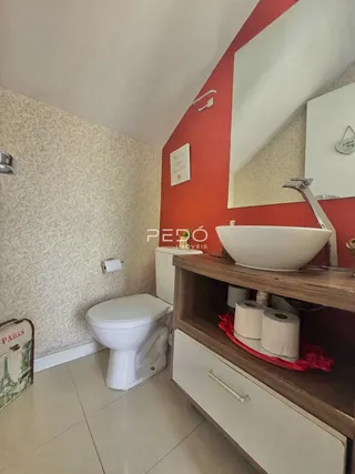 Foto de um banheiro com piso claro e azulejos brancos.